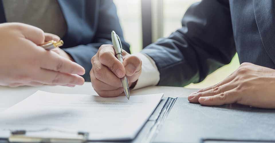 A Person signing a contract to buy home