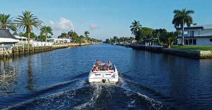 A boat sails in a canal in Pompano beach Florida