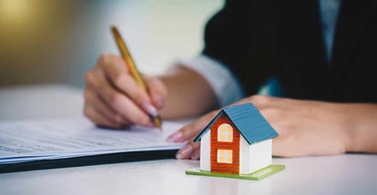 A buyer signing the purchase contract for a new house