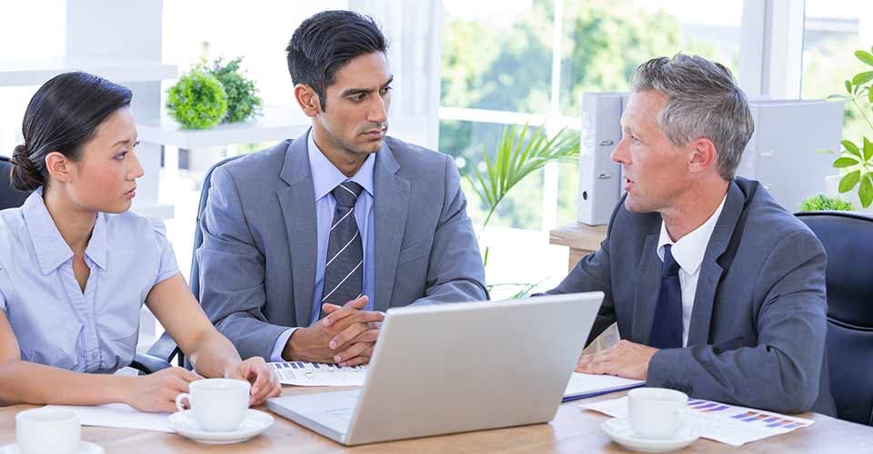 A couple meeting with real estate agent using laptop in the office