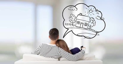 A couple sitting on a sofa in their new house