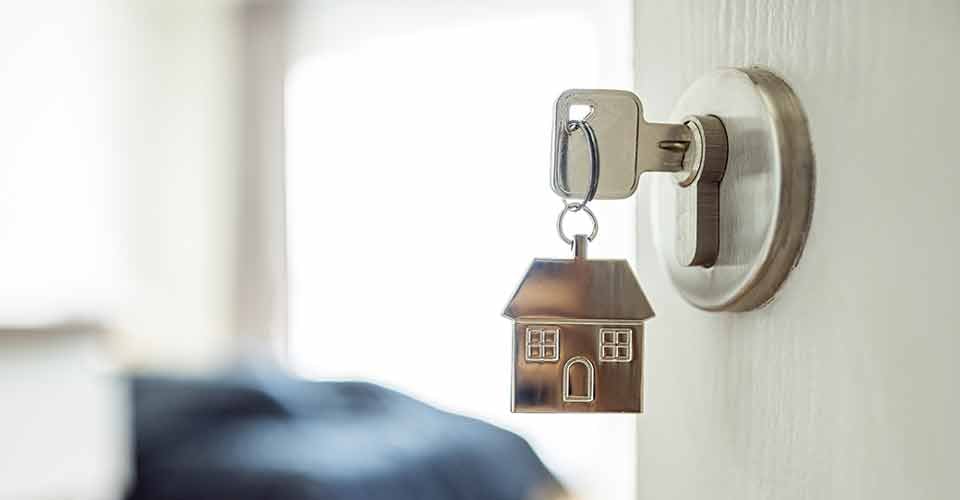 A door handle with a key and a keychain shaped house