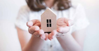 A hands holding paper house