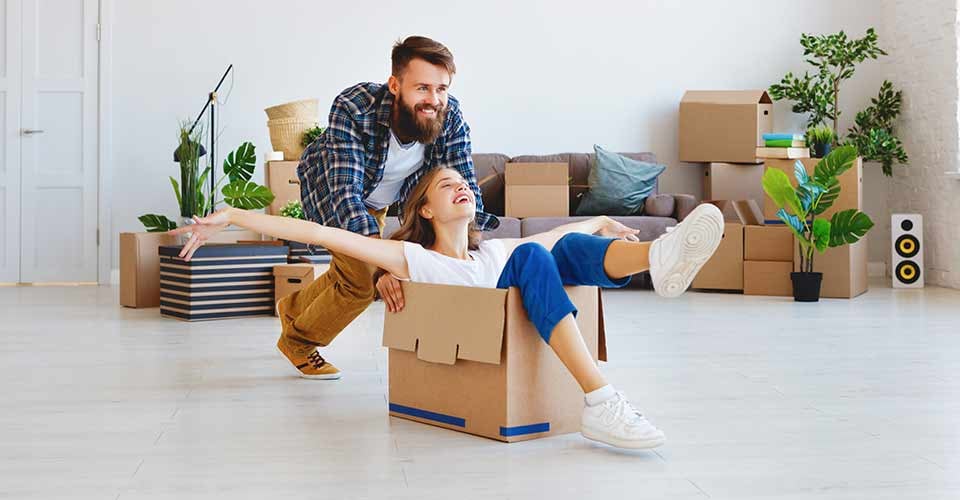 A happy young married couple moves to new home