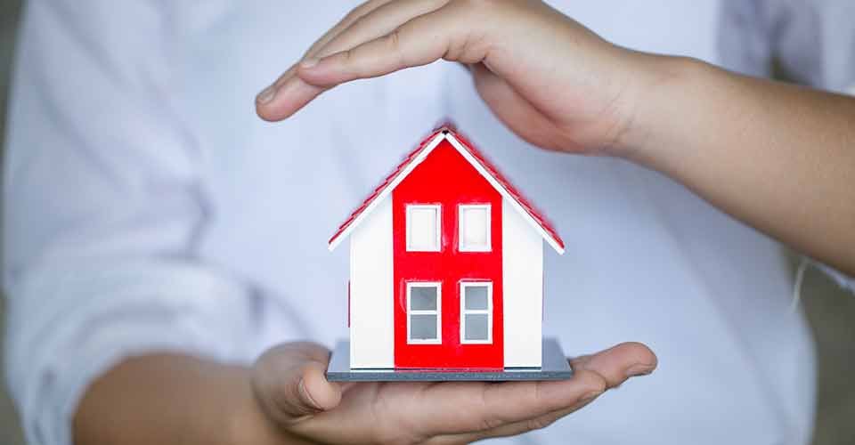 A home buyer holding a small house model