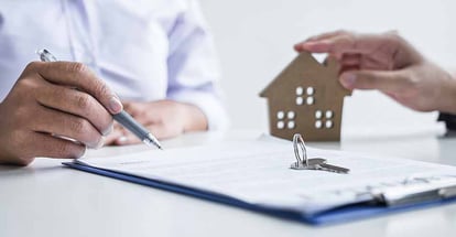 A home buyer signing contract to buy house