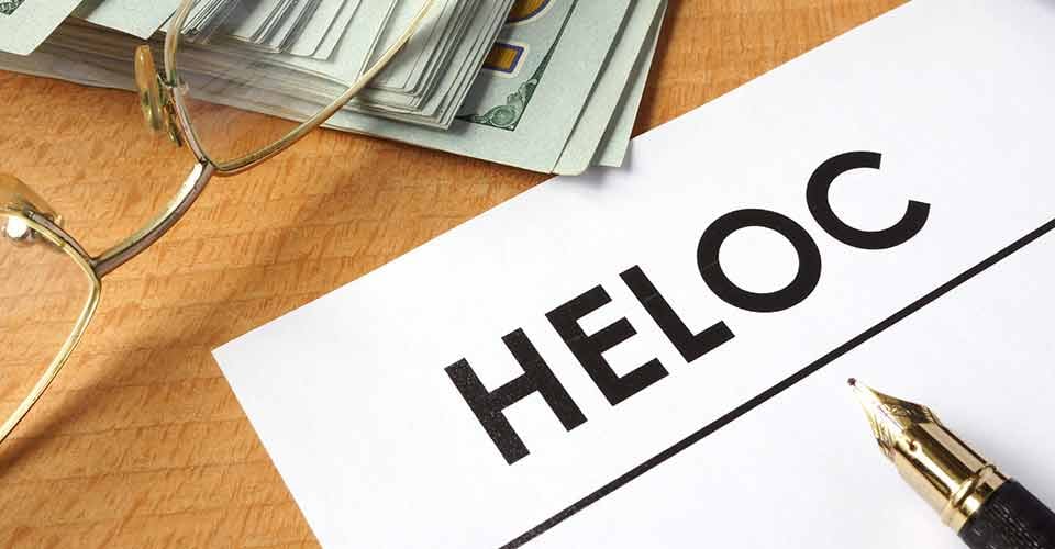 A paper with HELOC written on it and dollars
