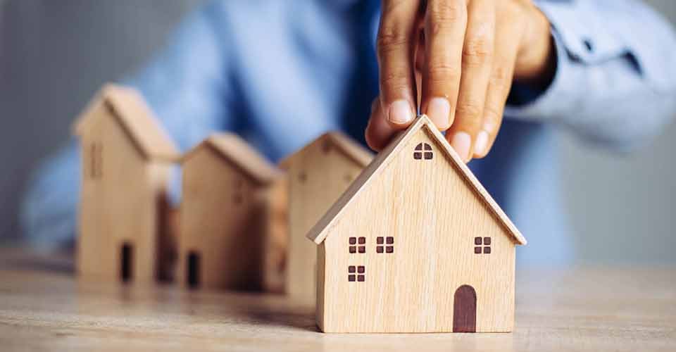 A person choosing mini wood house model