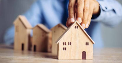 A person choosing mini wood house model