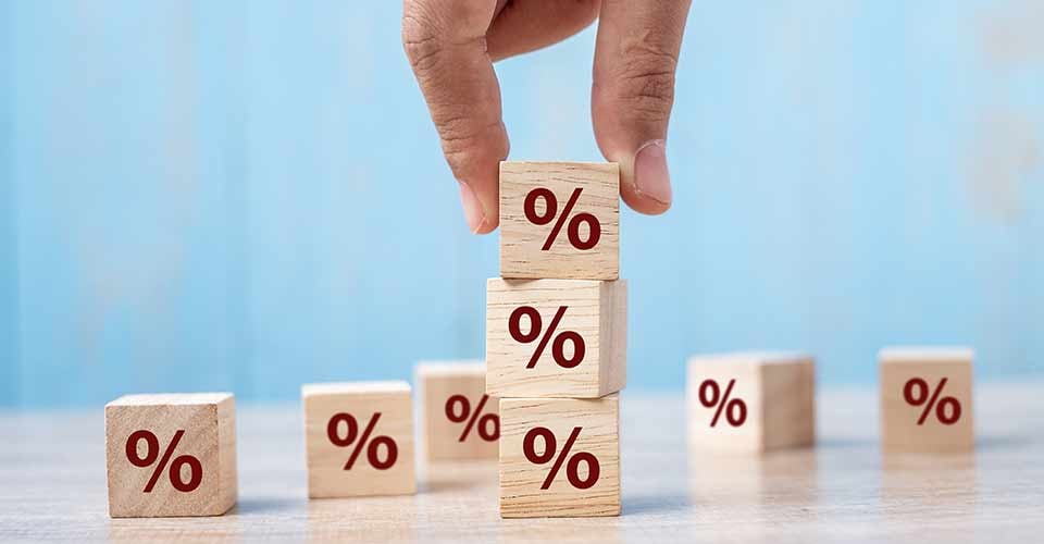 A person hand putting wood cube block with percentage symbol