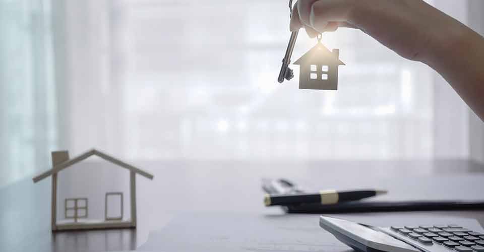 A person holding house key for investment property