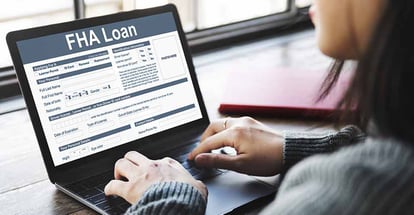 A person looking at online FHA loan application form on laptop