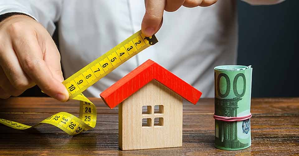A person measures and evaluates a house for renovation