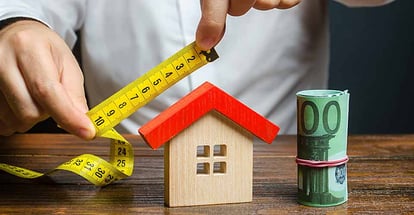 A person measures and evaluates a house for renovation