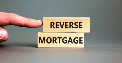 A person pointing at reverse mortgage words on wooden blocks