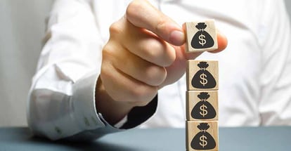 A person puts a block with dollar icon