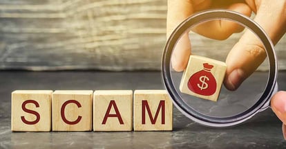 A person puts wooden blocks with the word Scam