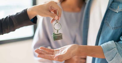 A person receiving a new home key from realtor
