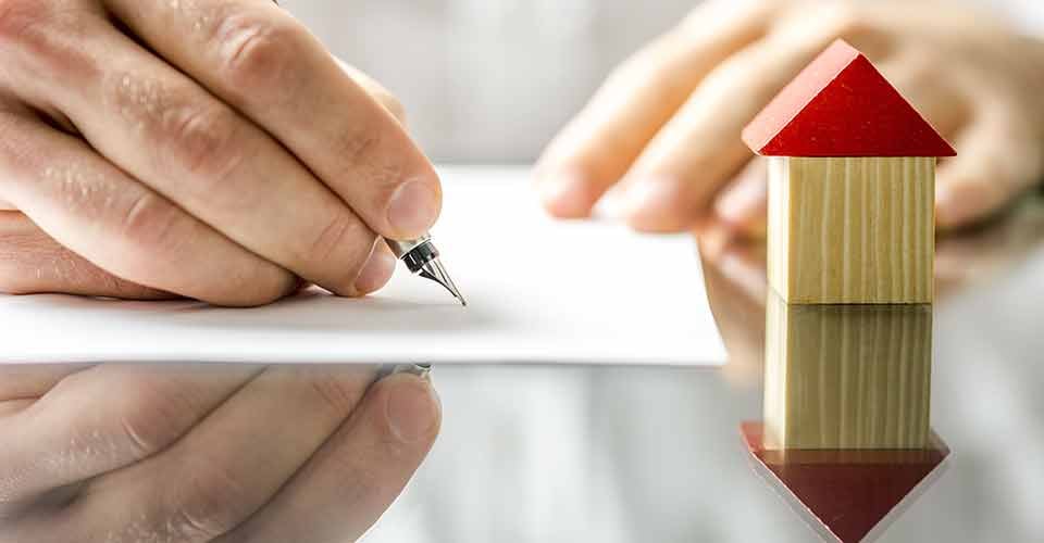 A person signing a contract when buying a new house