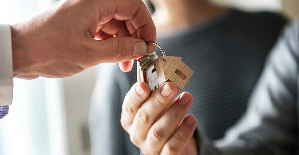 A person taking a new house key from realtor