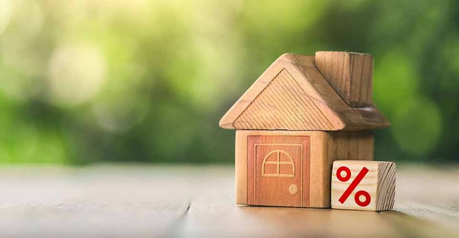 A small wooden house and percent symbol on cube