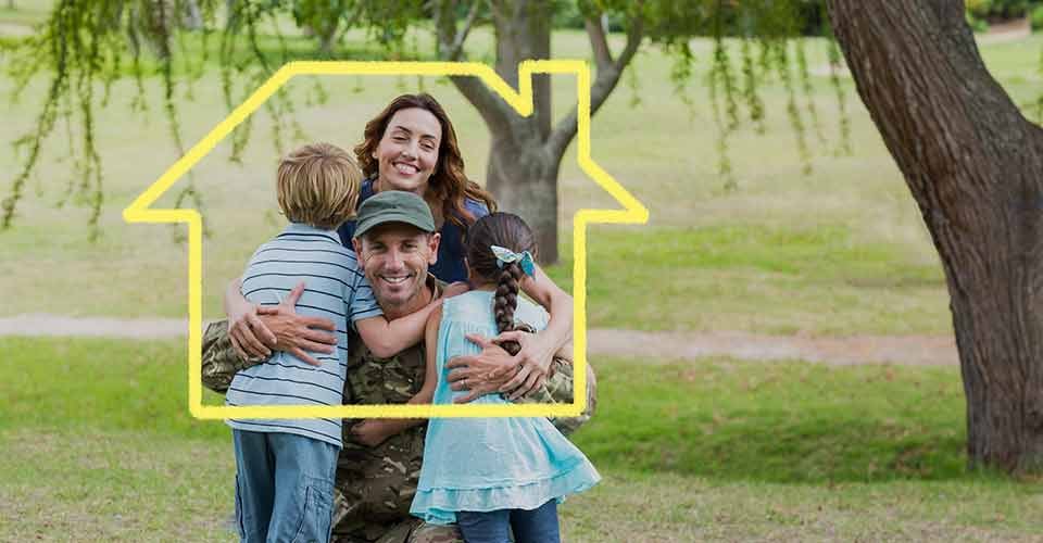 A soldier hugging his family outside home