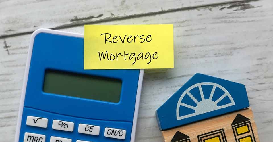 A sticky note with Reverse Mortgage written on it and calculator