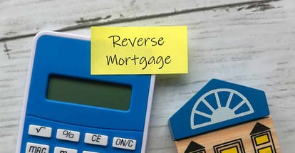 A sticky note with Reverse Mortgage written on it and calculator