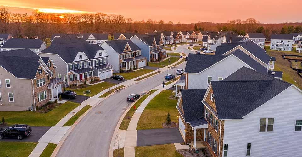Aerial sunset view of American neighborhood street with newly constructed single family homes