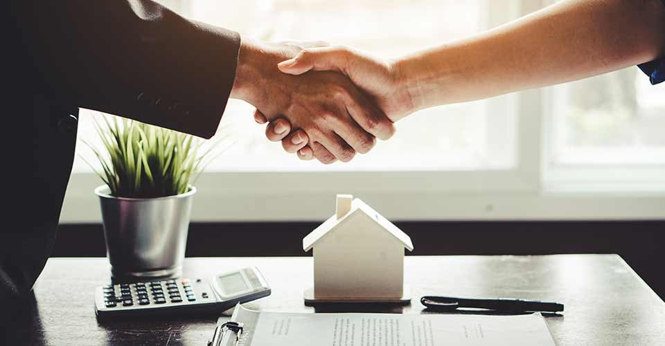 Agent and client shaking hands after signed document