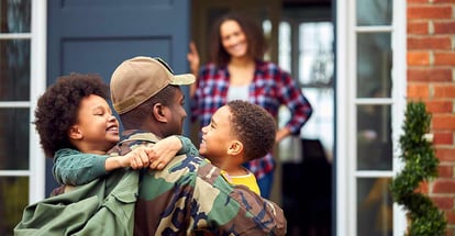 American Soldier In Uniform hugging Children Outside new House