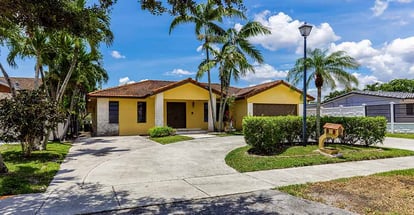 Beautiful front of a house with palm tree around it in Florida