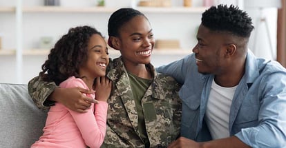 Black woman in uniform having conversation with her family in new home