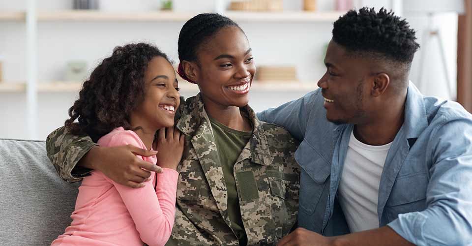 Black woman in uniform having conversation with her family in new home