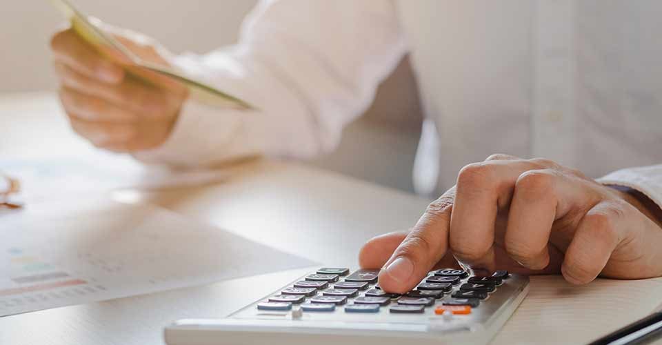 Close up hand of young male pressing a calculator to calculate mortgage payment