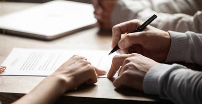 Close up view of a real estate agent showing client where to sign document