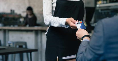 Closeup of a man giving credit card to waiter in cafe