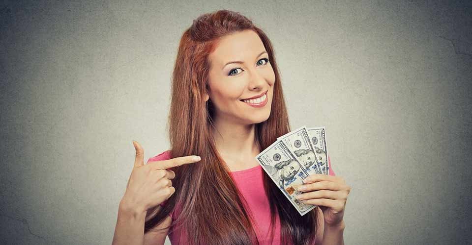Closeup portrait super happy excited successful young woman holding money dollar bills in hand