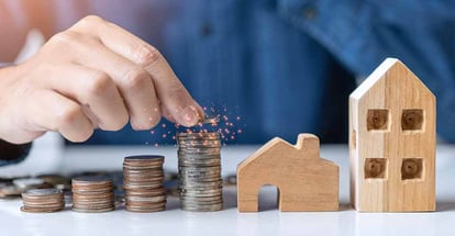 Coins stack and a person thinking about real estate investment