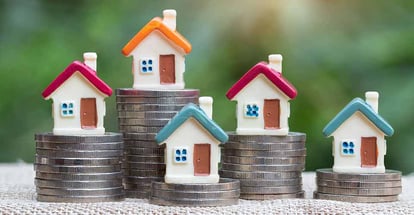 Coins stack with model house on top for real estate mortgage