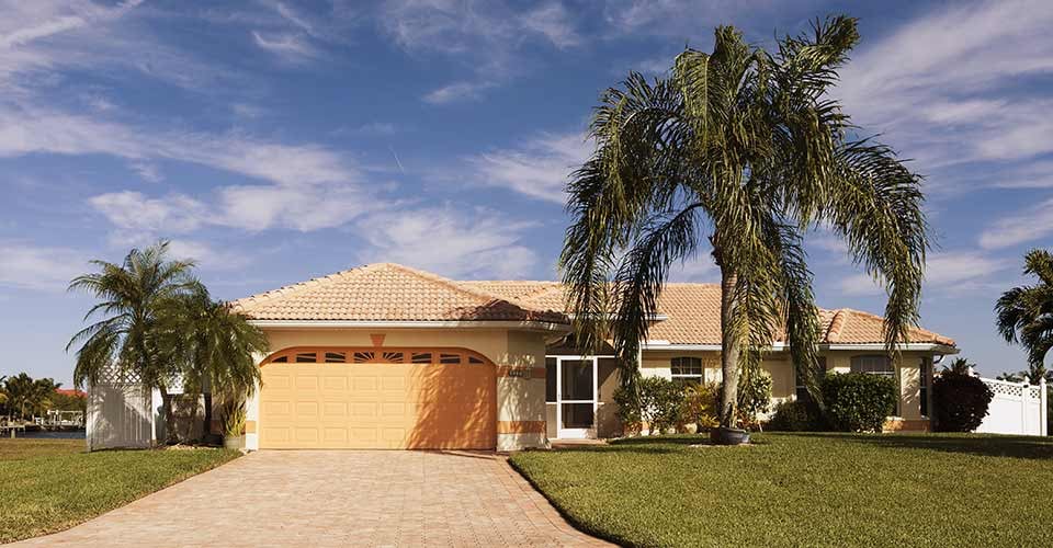 Concrete block and stucco home in Florida with palm trees