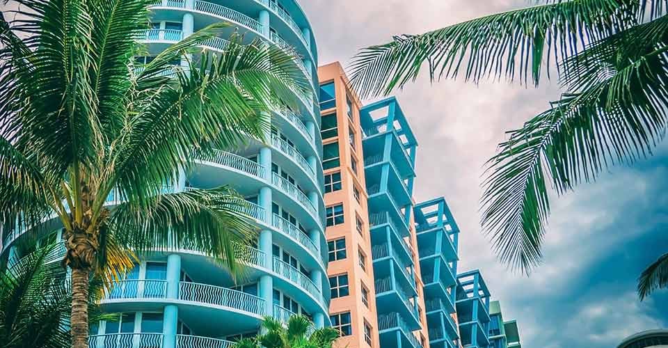 Condominium with palm trees against blue tropical sky in Miami Florida
