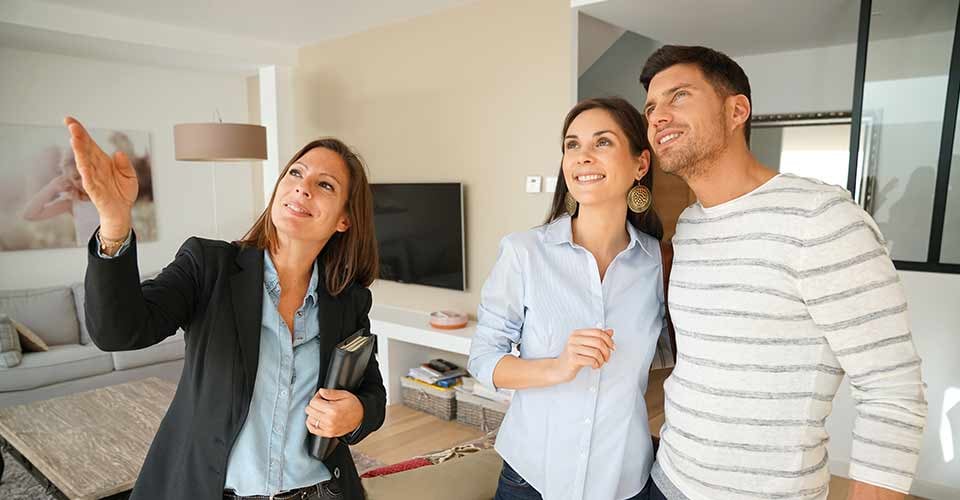 Couple with real estate agent visiting house for sale