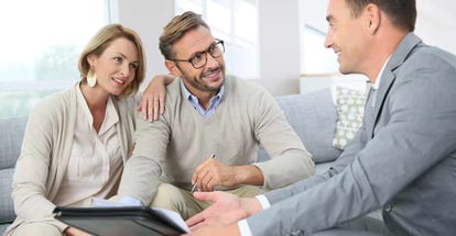 Couple with realtor signing mortgage contract