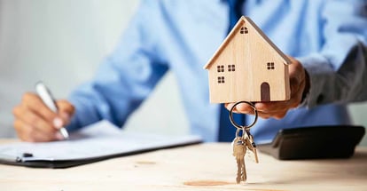 Customer holding house model and signing contract to buy house