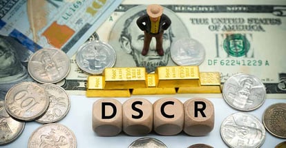DSCR word on wooden block and money to invest in real estate
