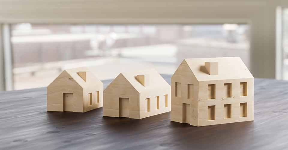 Different sized wooden model houses on table