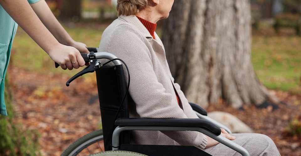 Disabled elder woman on wheelchair with nurse