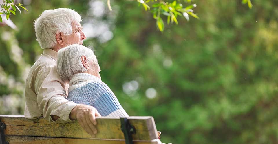 Elderly couple resting on a bench in the park