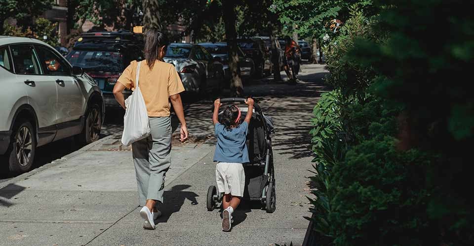 Ethnic mother and daughter with carriage